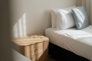 Sunlit bedroom with coastal styling at Poinciana Holiday House in Cooee Bay