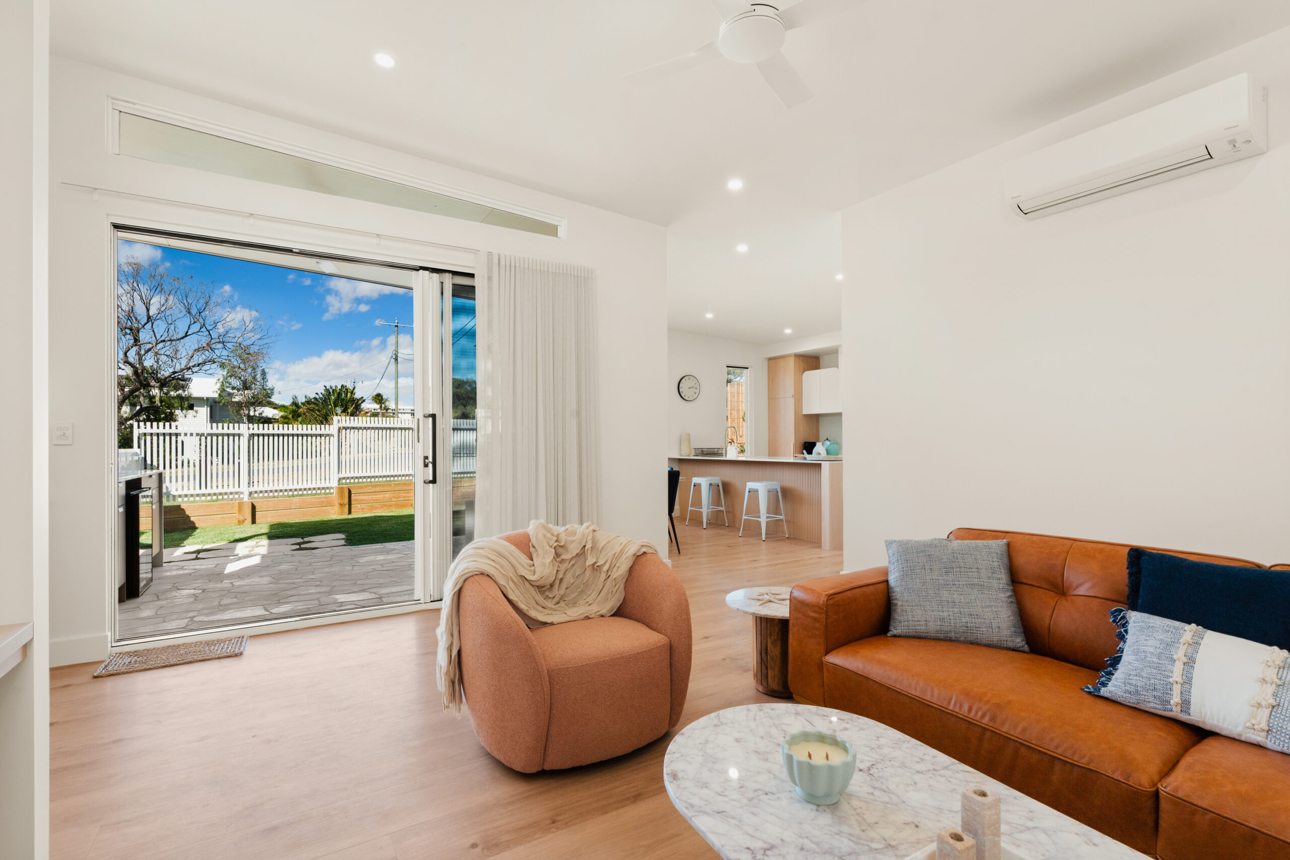 Open-plan living room with outdoor access at Poinciana Holiday House