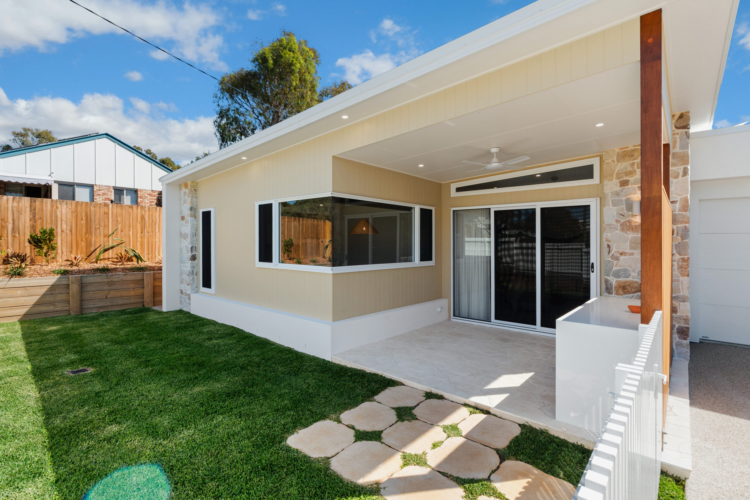 Covered outdoor patio and private lawn at Poinciana Holiday House